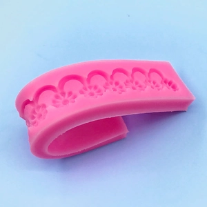 Pink silicone lace mold for cake borders with floral relief design and flexible texture