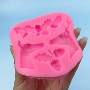 Pink silicone mold featuring reindeer heads and acorns for Christmas cake decorating