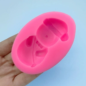 Pink snowman silicone mold for fondant and chocolate baking being held by hand