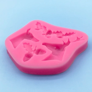 Pink Christmas silicone mold with reindeer and holly berry shapes for DIY cake decorating