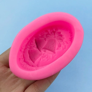 Pink silicone mold featuring Christmas bell and bow patterns for fondant and soap making