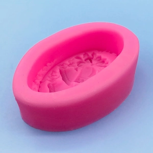 Pink silicone bell mold for Christmas cakes and soaps on a light blue background