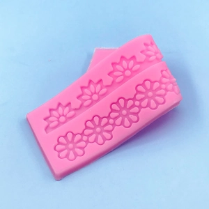 Pink silicone floral strip mold for fondant cake borders featuring daisy flower patterns