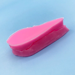Pink leaf-shaped silicone fondant mold for baking and flower decorating on blue surface