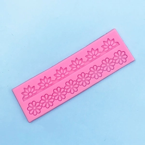 Macro detail of pink silicone mold featuring intricate floral lace and daisy patterns