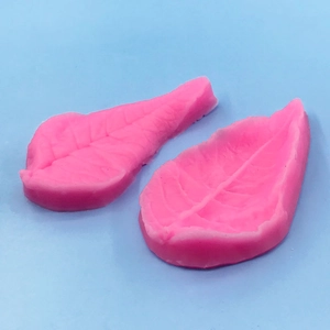 Macro shot of pink silicone leaf molds with realistic vein textures for cake decorating