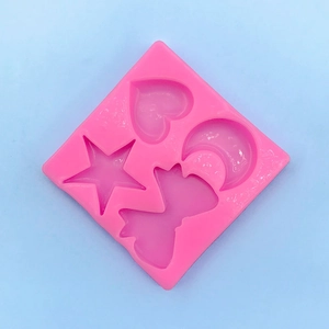 Close-up of pink silicone mold with star, heart, moon, and bow shapes for DIY baking