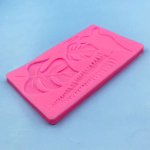 Pink silicone tropical leaf mold for chocolate cake decoration with monstera leaf patterns