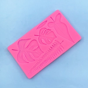 Detailed macro view of pink silicone leaf mold showing Monstera and palm leaf textures