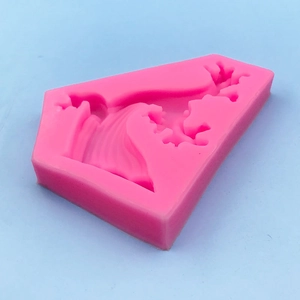 Pink wave-shaped silicone mold for DIY cake baking and plaster crafts from a top-down view