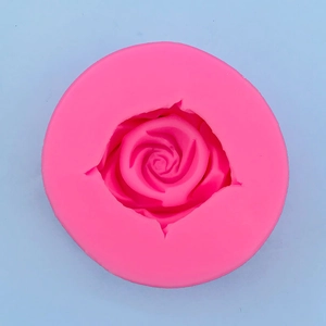 Macro detail of pink silicone mold featuring a large blooming rose pattern for fondant cake