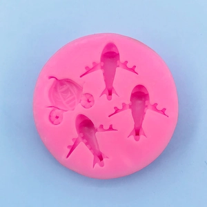 Detail of pink silicone mold with 4 cavities featuring airplane and carriage shapes