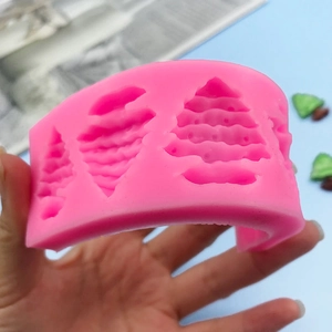 Pink silicone mold featuring three distinct Christmas tree shapes for DIY baking and crafts
