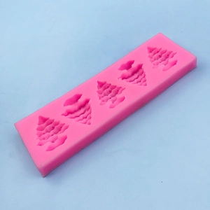 Pink silicone mold with four Christmas tree shapes for chocolate and fondant baking