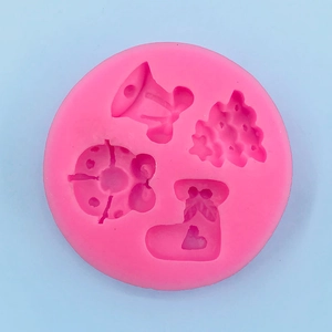 Top view of pink silicone mold with Christmas tree, bell, and sock patterns for baking