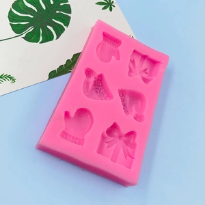 Pink silicone mold with 6 cavities featuring Christmas gloves and gift boxes for baking