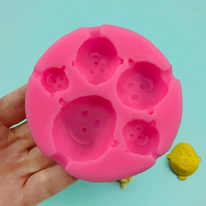 Pink silicone mold featuring five different cartoon smiley faces for DIY fondant and chocolate