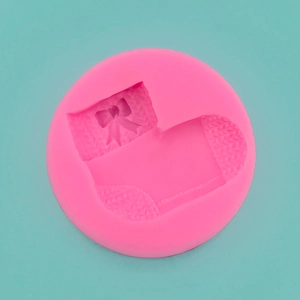 Macro view of pink silicone mold with detailed Christmas stocking and bow textures