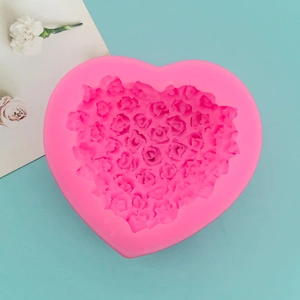 Close-up of pink heart-shaped silicone mold with detailed rose floral pattern for baking