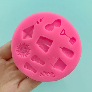 Pink silicone mold with beach elements like sun, slippers, and buckets for cake decorating