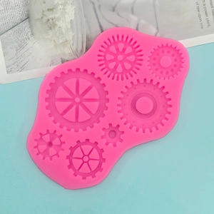 Macro detail of a pink silicone mold featuring seven unique gear and steampunk patterns