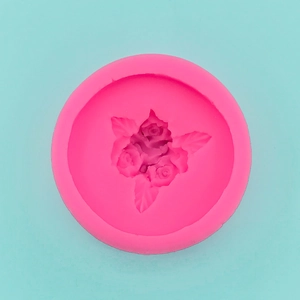 Macro detail of pink silicone mold with three intricate rose and leaf carvings