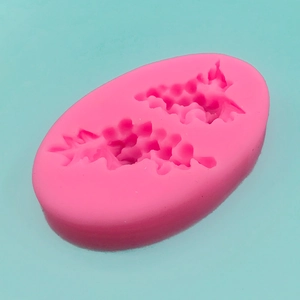 Pink silicone mold featuring two holly leaf shapes for DIY cake baking and candle making
