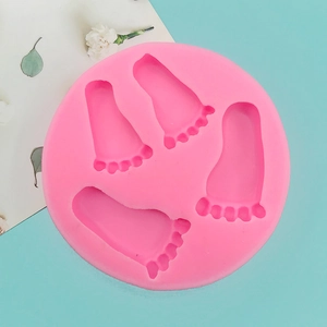 Détail du moule en silicone rose avec quatre cavités d'empreintes de bébé pour fondant