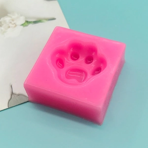 Pink paw print silicone mold for DIY soap, chocolate, and resin crafts on blue background