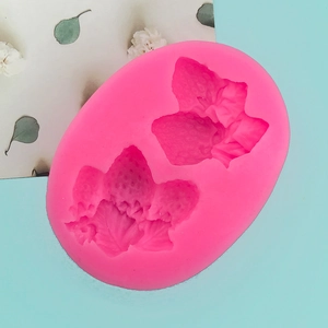 Detailed macro view of pink silicone mold featuring two realistic strawberry shapes