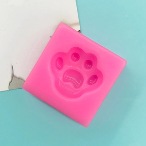 Macro view of pink square silicone mold featuring a detailed animal paw print texture