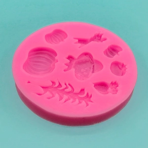 Rosa Silikonform für Kuchendekoration mit Muschelformen auf blauem Hintergrund