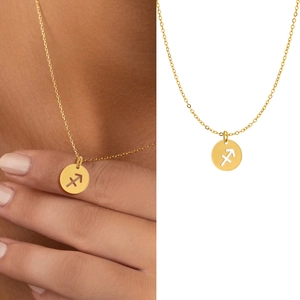 Detail of a gold Sagittarius zodiac pendant necklace with hollow circular design on a model