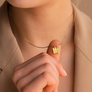 Close-up van 14K vergulde roestvrijstalen ketting met gegraveerde hanger van letter K