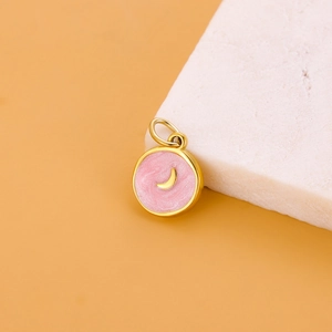 Detail of round golden pendant with pink enamel and crescent moon for DIY jewelry making