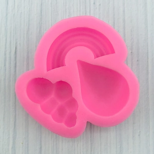 Macro detail of a pink silicone mold featuring rainbow, water drop, and cluster shapes