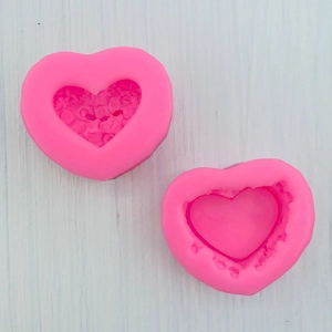 Detail view of heart-shaped silicone molds with rose floral patterns for DIY crafting