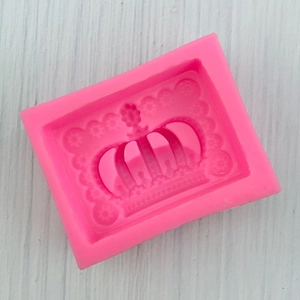 Detailed macro view of pink silicone mold featuring intricate crown and floral patterns