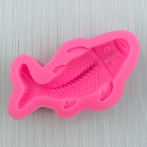 Detail of pink fish silicone mold showing intricate scales and fin textures for fondant
