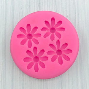 Vue macro du moule en silicone rose à quatre cavités marguerites pour fondant et résine