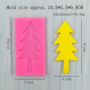 Pink silicone tree mold with yellow resin Christmas tree model on wood background