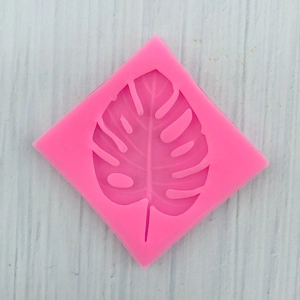 Vista dettagliata dello stampo in silicone rosa con trame di foglie di monstera
