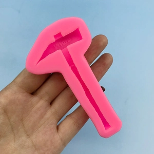 Pink silicone hammer mold for DIY cake topper and resin crafts on blue background