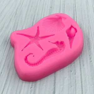 Pink marine life silicone mold featuring seahorse, starfish, scallop and conch shapes