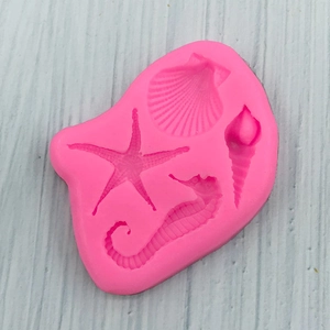 Detail of pink silicone mold featuring starfish, scallop, seahorse and seashell shapes