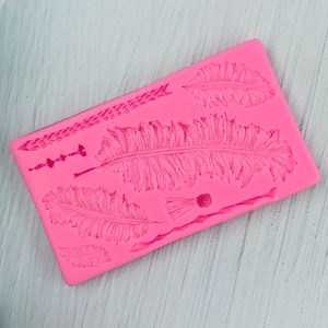 Detailed pink silicone mold featuring various sizes of feather shapes for DIY cake decor