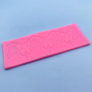 Pink silicone fondant mold featuring intricate floral lace patterns for cake decorating