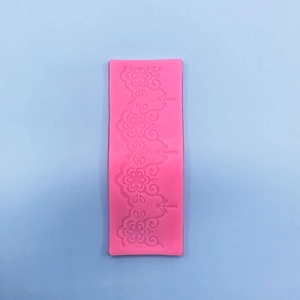 Macro detail of pink silicone fondant mold with intricate floral lace relief patterns