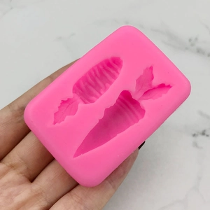 Pink carrot-shaped silicone mold for DIY cake decorating and soap making in hand