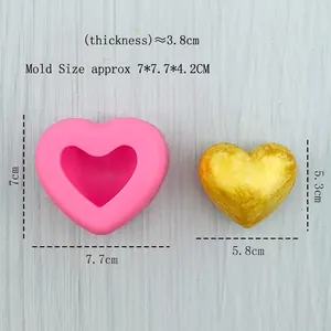 Pink heart silicone mold with gold resin heart on a light blue wooden texture background
